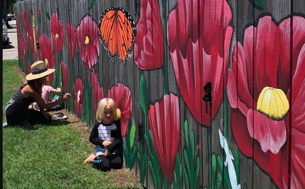 mother and daughters painting fence mural in baldwin county